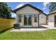 A cozy backyard shows a sliding glass door, paver patio, lush green grass, and a modern exterior at 1914 E Chelsea St, Tampa, FL 33610
