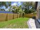 Backyard featuring a new wooden fence, stone paver path, and a lush green lawn at 1914 E Chelsea St, Tampa, FL 33610