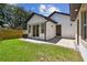 A well maintained backyard featuring a paver patio, lush green grass, and a modern exterior with updated windows at 1914 E Chelsea St, Tampa, FL 33610