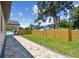 Landscaped backyard with a stone paver path, a new wooden fence and lush green lawn at 1914 E Chelsea St, Tampa, FL 33610