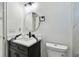 Well-lit bathroom with a black and white vanity, round mirror, and modern finishes at 1914 E Chelsea St, Tampa, FL 33610