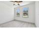 Bright bedroom with light wood floors, a ceiling fan, and large windows at 1914 E Chelsea St, Tampa, FL 33610