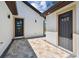 Exterior view of the home with stone paver patio, doors and lighting at 1914 E Chelsea St, Tampa, FL 33610