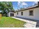Exterior shot of the home with detached garage, showing the paved path and well-maintained lawn at 1914 E Chelsea St, Tampa, FL 33610