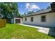 Exterior view of the home and detached garage, highlighting the paved path and lawn at 1914 E Chelsea St, Tampa, FL 33610