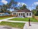 Charming home featuring a inviting front porch, brick pillars, fresh landscaping, and a new walkway and lawn at 1914 E Chelsea St, Tampa, FL 33610