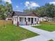 Charming single-story home with inviting front porch, brick pillars, fresh landscaping, and a new walkway at 1914 E Chelsea St, Tampa, FL 33610
