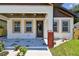 Close-up of a front porch with a gray stone patio, recessed lighting, and colorful flower accents at 1914 E Chelsea St, Tampa, FL 33610