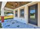 Inviting front porch featuring a patterned blue floor, wood plank ceiling, and a stylish black front door at 1914 E Chelsea St, Tampa, FL 33610