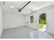 View of the garage with epoxy flooring, an overhead door, and a window for natural light at 1914 E Chelsea St, Tampa, FL 33610