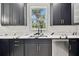A close up of a modern kitchen with black cabinets, white countertops, and subway tile backsplash at 1914 E Chelsea St, Tampa, FL 33610