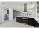 Open concept kitchen featuring stainless steel appliances and black cabinetry with eat in space and view to the formal living room at 1914 E Chelsea St, Tampa, FL 33610
