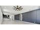 Spacious living room features open layout, modern ceiling fan, paneled wall, and hardwood floors at 1914 E Chelsea St, Tampa, FL 33610