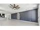 Open living area with paneled accent wall, modern ceiling fan, and access to kitchen at 1914 E Chelsea St, Tampa, FL 33610