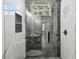 Modern shower boasting gray marble surround, showerhead, and glass door and walls at 1914 E Chelsea St, Tampa, FL 33610