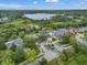 Aerial view of a home on a corner lot with lake views surrounded by lush landscaping at 21108 Bircholm Ct, Land O Lakes, FL 34637