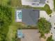 Aerial view of a home featuring a screened-in pool and spa with a gray roof at 21108 Bircholm Ct, Land O Lakes, FL 34637