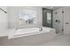 Well lit soaking tub with adjacent glass enclosed shower and natural light from a window at 21108 Bircholm Ct, Land O Lakes, FL 34637