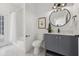 Bathroom featuring modern vanity, round mirror, stylish light fixture and tub shower combo at 21108 Bircholm Ct, Land O Lakes, FL 34637