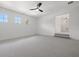 Bedroom with light gray carpeting and all-white walls adjacent to an elevated space with stairs at 21108 Bircholm Ct, Land O Lakes, FL 34637