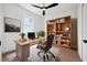 Home office with modern desk, chair, natural light, and a well-stocked bookshelf at 21108 Bircholm Ct, Land O Lakes, FL 34637