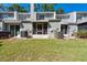 Exterior of townhomes with screened in patios and green grass in the backyard at 2175 Fox Chase Blvd, Palm Harbor, FL 34683