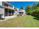 Green backyard and view of back of townhomes with enclosed porches at 2175 Fox Chase Blvd, Palm Harbor, FL 34683