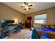 Well-lit bedroom featuring wood floors, a ceiling fan, workspace, and comfortable sleeping area at 2175 Fox Chase Blvd, Palm Harbor, FL 34683