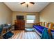 Well-organized bedroom with a workstation, TV, laminate flooring, and a bright window at 2175 Fox Chase Blvd, Palm Harbor, FL 34683