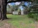 View of large backyard with two storage sheds and mature trees, offering space for outdoor activities at 222 Spring Lake Hwy, Brooksville, FL 34602