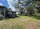 Spacious backyard with a screened-in porch, trees, and landscaping at 222 Spring Lake Hwy, Brooksville, FL 34602