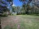 Large, open backyard space with mature trees creating privacy and natural beauty at 222 Spring Lake Hwy, Brooksville, FL 34602
