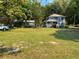 Well-maintained front yard with lush green grass and a charming two-story house in the background at 222 Spring Lake Hwy, Brooksville, FL 34602