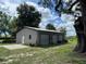 Exterior of a large garage with three roll-up doors on a grassy lot at 222 Spring Lake Hwy, Brooksville, FL 34602