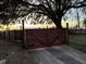 A dark brown wooden entrance gate to the property has an automatic opening mechanism and sturdy pillars at 222 Spring Lake Hwy, Brooksville, FL 34602