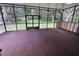 Spacious screened-in patio with a wood floor and a view of the lush backyard at 222 Spring Lake Hwy, Brooksville, FL 34602