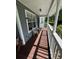 Inviting front porch featuring wood flooring, white columns, and comfortable seating at 222 Spring Lake Hwy, Brooksville, FL 34602