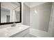 Modern bathroom featuring a tub with light gray tile surround and a white vanity at 2511 N Grady Ave # 43, Tampa, FL 33607