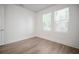 Clean, empty bedroom with hardwood floors, base trim and two windows offering lots of natural light at 2511 N Grady Ave # 43, Tampa, FL 33607