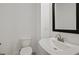 Clean powder room featuring a black framed mirror, an elegant sink, a toilet, and tile flooring at 2511 N Grady Ave # 43, Tampa, FL 33607