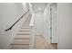 Bright foyer with staircase, featuring hardwood floors and a black handrail leading to the upper level at 2511 N Grady Ave # 43, Tampa, FL 33607
