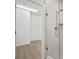 Bright walk-in closet boasts laminate flooring and shelving, accessible through a doorway near a tiled shower at 2511 N Grady Ave # 43, Tampa, FL 33607