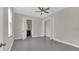 Spacious bedroom with gray floors, a ceiling fan, and a view into the ensuite bathroom at 2627 Hancock St, Plant City, FL 33563