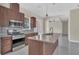 Modern kitchen featuring dark wood cabinets, stainless steel appliances, and an island with sink at 2627 Hancock St, Plant City, FL 33563