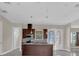 Modern kitchen featuring dark wood cabinets, stainless steel appliances, and an island with sink at 2627 Hancock St, Plant City, FL 33563