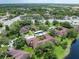 Aerial view captures the buildings near a pond and verdant landscapes with mature trees at 2681 Sabal Springs Cir # 204, Clearwater, FL 33761