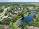 Aerial view showcases a community with condos, lush foliage, and a tranquil pond at 2681 Sabal Springs Cir # 204, Clearwater, FL 33761