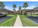 Exterior view of condo with lush landscaping, sidewalk, covered parking, palm trees, and serene environment at 2681 Sabal Springs Cir # 204, Clearwater, FL 33761