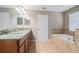 Bathroom with granite countertops on double sink vanity, separate tub and tiled floor at 2706 Lantern Hill Ave, Brandon, FL 33511