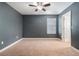 Dark walled bedroom features ceiling fan, carpet, and natural light from large window at 2706 Lantern Hill Ave, Brandon, FL 33511